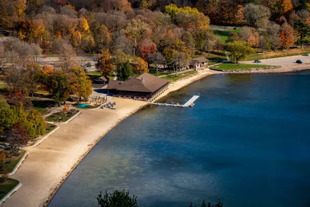 An aerial view of Devil's Lake with coastline tress and buildings in autumn near Baraboo, Wisconsin