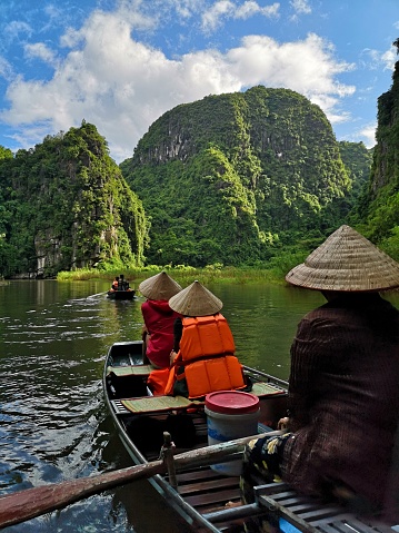 A vertical shot of the tourists traveling in boats in Ninh Binh, Viet