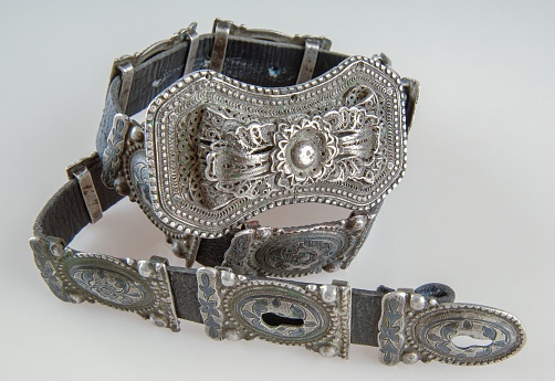 An antique, silver belt isolated on a white background, close-up