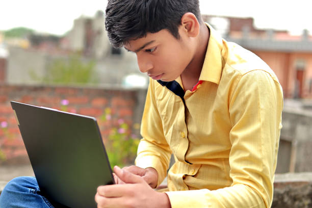 istock Indian teenage boy using laptop 1436920108