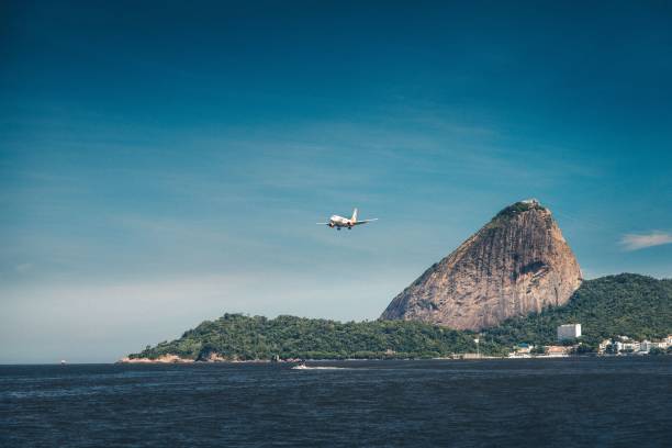 samolot przygotowujący się do lądowania nad atlantykiem w rio z górą głowa cukru w tle - rio de janeiro sugarloaf mountain brazil sugarloaf zdjęcia i obrazy z banku zdjęć