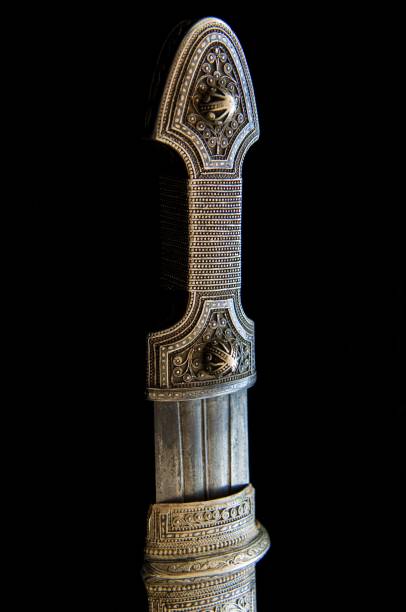 istock Handle of an antique dagger with artistic chasing and engraving on a black background 1436923449