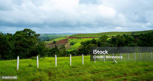 Landscape With Green Field And Fenced Area Under Cloudy Sky In Mondulkiri Province In Cambodia Stock Photo - Download Image Now
