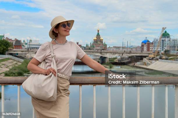 Portrait Of Travelling Woman In Hat Against The Backdrop Of The River And City Stock Photo - Download Image Now