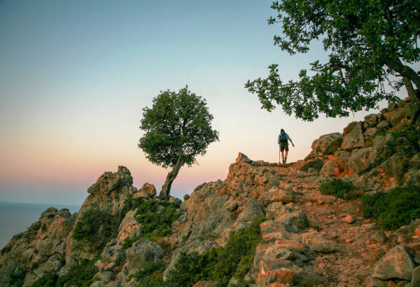 Loutro, Greece – May 04, 2007: A rear view of a backpacker climbing a mountain in Crete, Greece