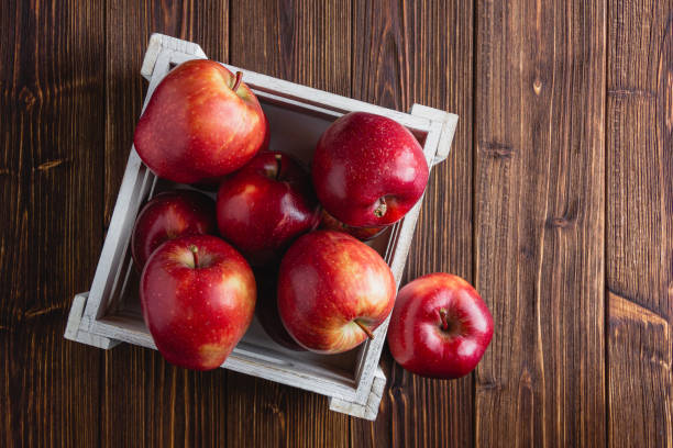 istock Red apples in a crate on a wooden background. 1436927977
