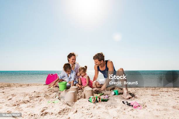 Young Happy Family Playing With Beach Toys In Sand Stock Photo - Download Image Now