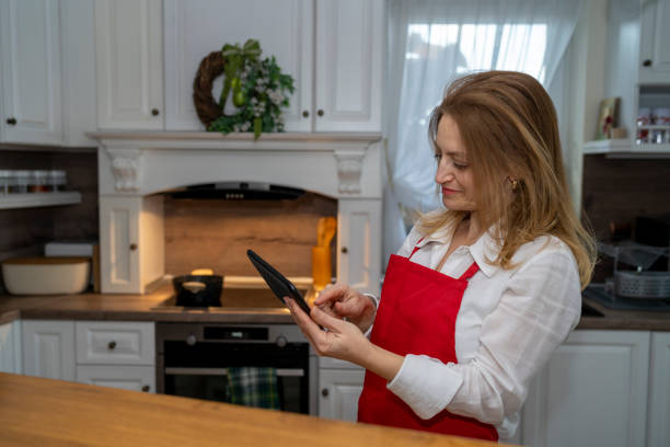 istock Woman using mobile digital tablet in the kitchen 1436928806