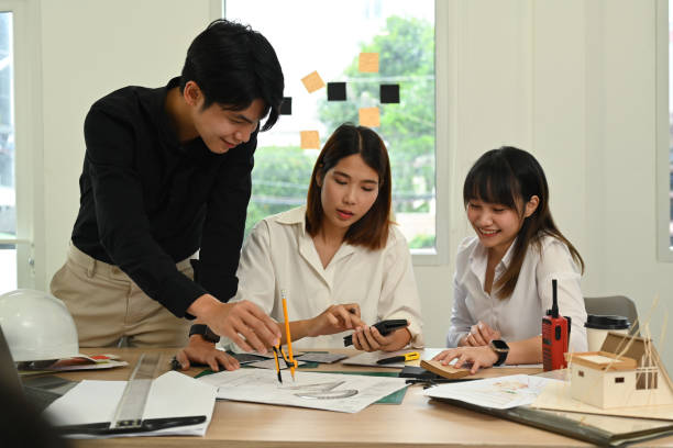 istock Group of creative people working on scale model house, preparing presentation to client at modern office. 1436931756