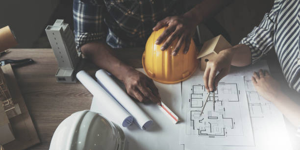 istock Builder two asian young engineer man and architect woman are discussing construction from a plan to follow the project to build an industrial plant at site. Worker concept. 1436936280