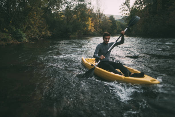 Man paddling kayak on river. Whitewater kayaking.