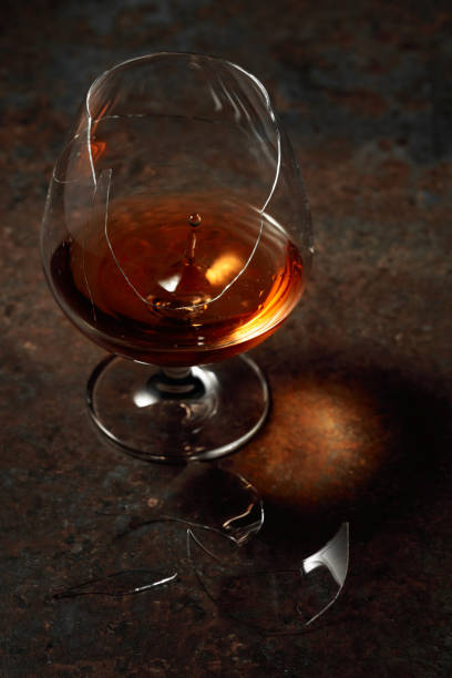 istock The drop of brandy falls into a broken glass. 1436937212