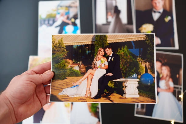 istock printed wedding photos on a black background and in hand. 1436940311