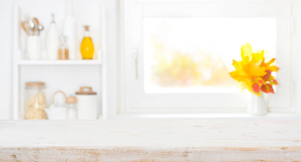 Blurred kitchen window background and wooden table space in front