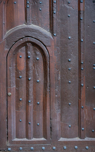 Weathered wood doorway in wooden wall.