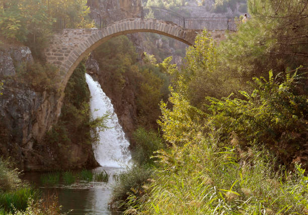 istock waterfall flowing under the historical bridge and river in greenery 1436942400