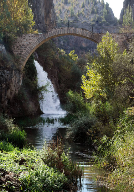 istock waterfall flowing under the historical bridge and river in greenery 1436942426