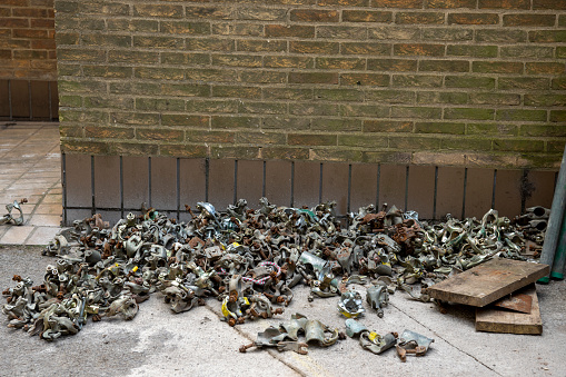 Pile of scaffolding clasps on the ground near a building site in Cambridge.