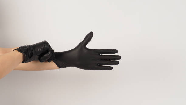 istock The hand is pulling black latex gloves  on white background. 1436944170