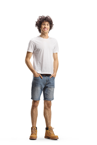 Full length portrait of a tall young man with curly hair smiling isolated on white background