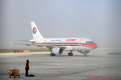 Jiuzhai, Sichuan- September 12, 2010: An air travel from Beijing International Airport to Jiuzhai Huanglong Airport, Sichuan Province, via Xi‘an Xianyang Airport, Shaan'xi Province. Here is an Airbus 319 airplane of China Eastern Airlines in Jiuzhai Huanglong Airport.