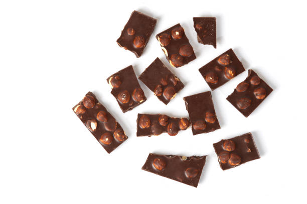 istock Small pieces of chocolate with nuts on a white background. top view 1436944262