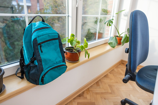 Blue school backpack, near window