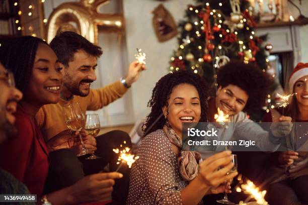 Multiracial Group Of Happy Friends Using Sparklers And Having Fun On New Years Day At Home Stock Photo - Download Image Now