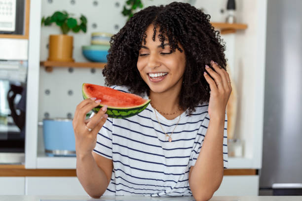 istock Beautiful African Mother eating Watermelon at Home Kitchen 1436949613