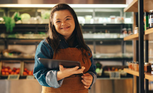 istock Grocery store owner with Down syndrome smiling at the camera 1436950961