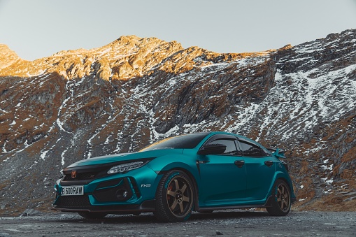 Trasfagarasan, Romania – October 21, 2022: A beautiful blue Honda Civic Type-R sportscar in The Romanian mountains on a sunny morning