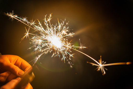 A selective focus shot of man's hand holding a sparkler