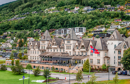 Voss, Norway - August 17 2022: View of the village on the slopes of the mountain. Fleischer’s Hotel, built in 1889, dominates the picture.