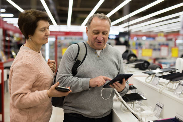 Senior couple choosing tablet in tech store