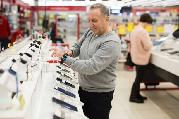 istock Aged man choosing digital wristwatches in electronic store 1436960970