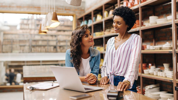 istock Two young ceramists smiling at each other in their shop 1436961135