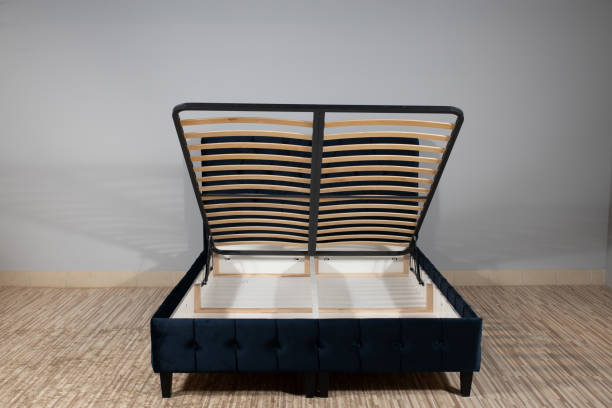 istock Bed with blue upholstery without mattress in an empty room and opened storage 1436965058