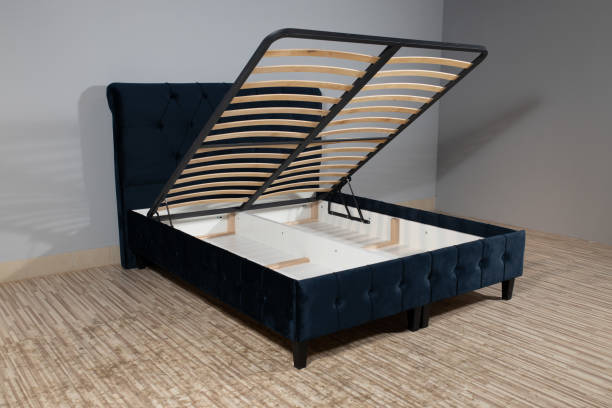 istock Bed with blue upholstery without mattress in an empty room and opened storage 1436965063