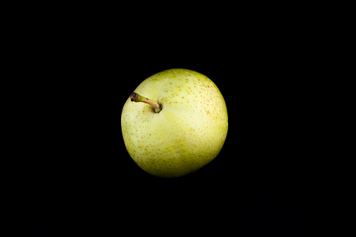 A pear, black background