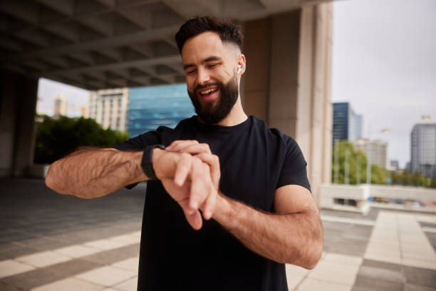 istock Smiling man checking his fitness tracker during a city run 1436971501