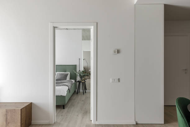 istock Modern minimalistic bedroom interior design with light green bed, eucalyptus in glass vase. Scandinavian style.  Aesthetic simple interior design concept. 1436971502