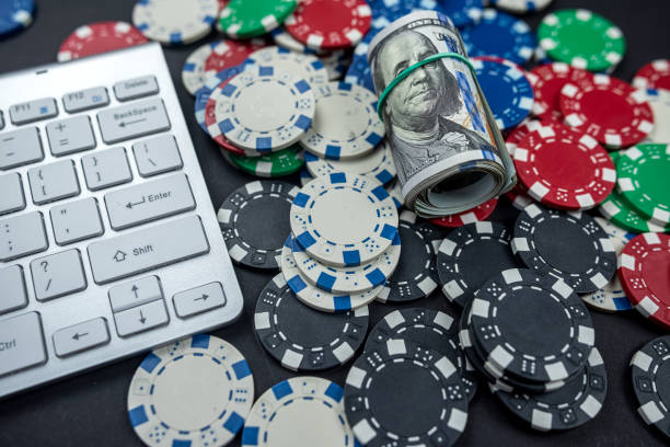 istock poker chips for poker with banknotes twisted placed on laptop keyboard. 1436971886