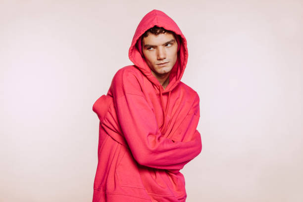 istock Young man with pink hoodie posing at studio 1436972950