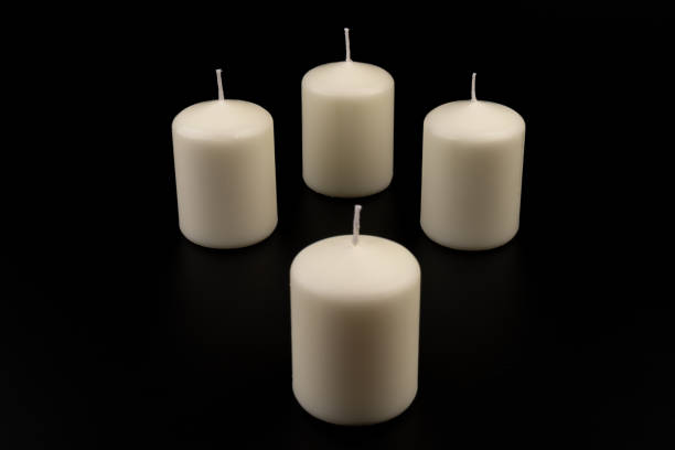 istock White candles on dark background. Close-up, copy space. 1436974094