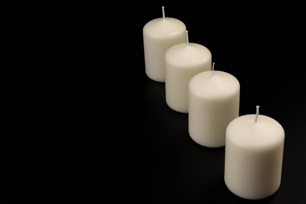 istock White candles on dark background. Close-up, copy space. 1436974100