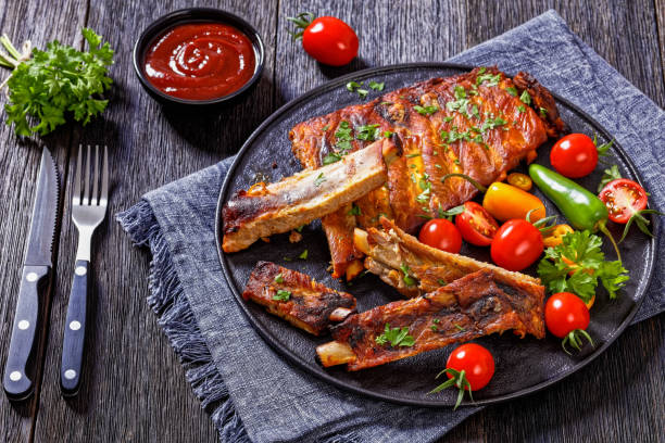 istock BBQ Ribs with tomatoes and chili on  black plate 1436975235