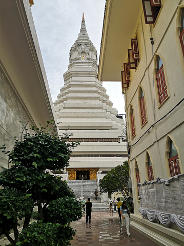 People walking at Wat Paknam Bhasicharoen, a royal Wat in Phasi Charoen district, Thailand. The stupa is 80 mt tall.