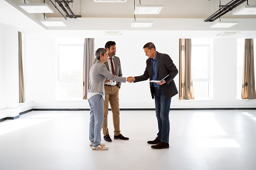 Caucasian male real estate agent handshake with a clients, after he sold/rent the property to them