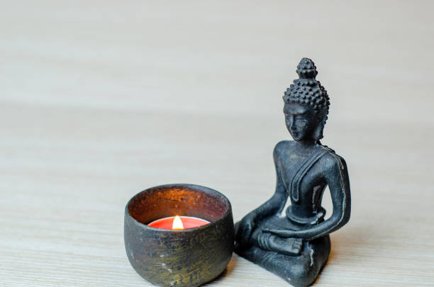 istock Buddha statue on a light background, candles, minimalism 1436980300