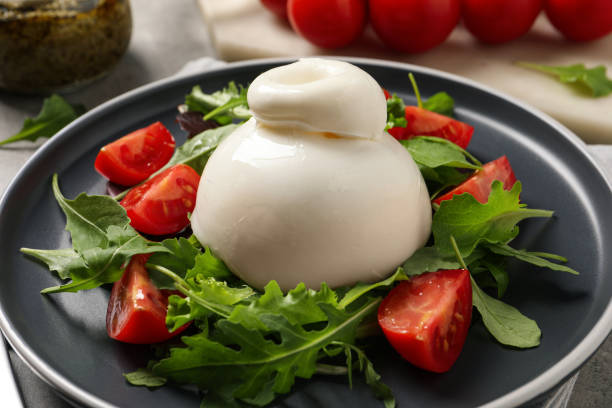 istock Delicious burrata salad with tomatoes and arugula on table, closeup 1436981530